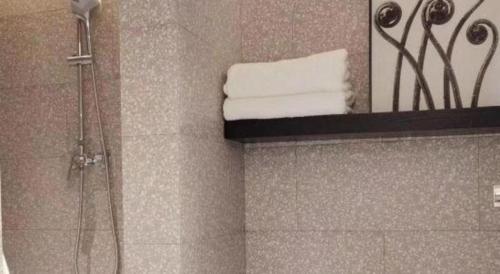a bathroom with a shower and a mirror at Zaozhuang Hotel in Zaozhuang