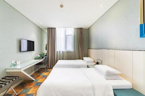 a hotel room with three beds and a television at Zaozhuang Hotel in Zaozhuang