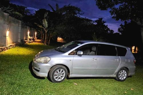 a silver car parked in the grass at night at Mambo Number Five in Entebbe