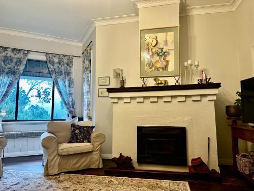 - un salon avec une cheminée et une chaise dans l'établissement Hilltop Cottage, à Bridgetown