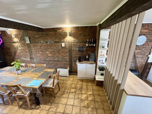 a dining room with a table and a brick wall at Chez Béné in Rochefort
