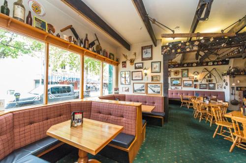 a restaurant with tables and chairs and windows at Rutland Arms Inn in Whanganui