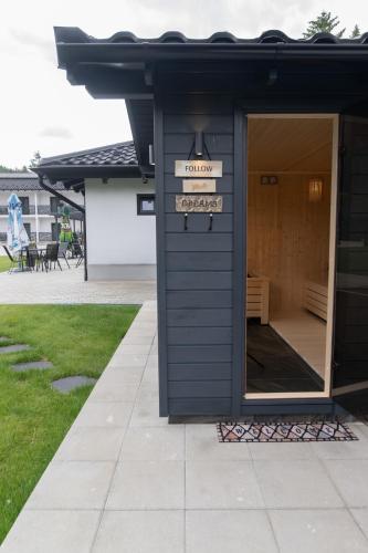 a black building with a sign in a yard at Casa de Vacanta Magherus in Topliţa