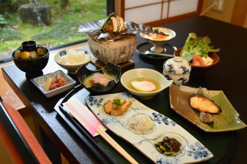 a table with plates of food and chopsticks on it at Kawakamiya Kasuitei in Gero