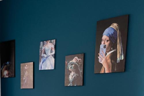 a wall with pictures of a woman holding a cell phone at Sea Breeze Suites in Livorno