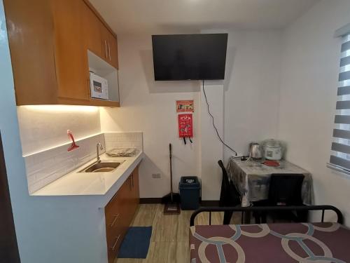 a small kitchen with a sink and a microwave at Skyblue Boarding House Rental in Ipil