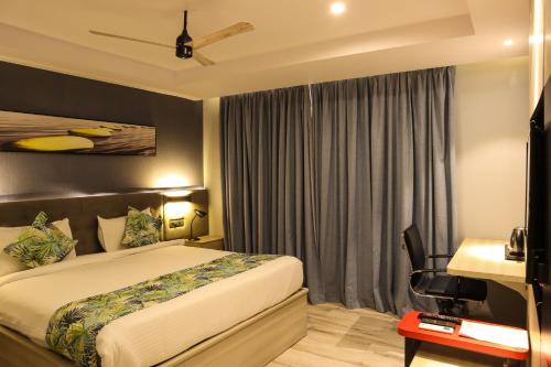 a bedroom with a bed and a desk and a television at HOTEL OCEAN VISTA BAY in Visakhapatnam