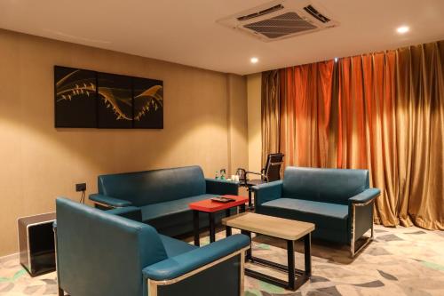 a waiting room with blue chairs and a table at HOTEL OCEAN VISTA BAY in Visakhapatnam
