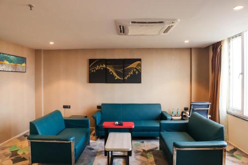 a waiting room with blue chairs and a table at HOTEL OCEAN VISTA BAY in Visakhapatnam