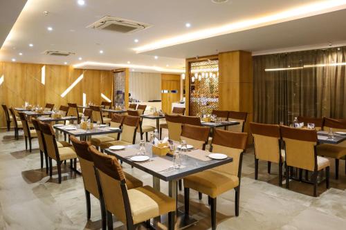 a restaurant with tables and chairs in a room at HOTEL OCEAN VISTA BAY in Visakhapatnam