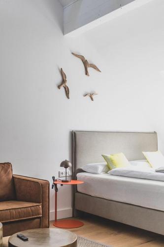 a bedroom with a bed with birds on the wall at Appartements Brigg & Schoner in Neuharlingersiel