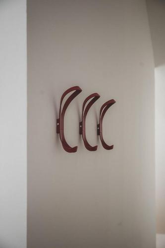 a metal sign on a white wall with the letters dc at Appartements Brigg & Schoner in Neuharlingersiel