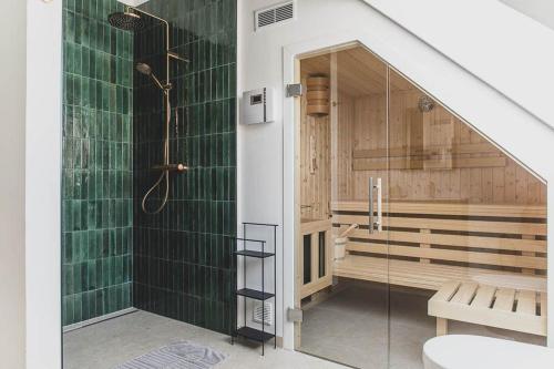 a bathroom with a shower with green tiles at Appartements Brigg & Schoner in Neuharlingersiel