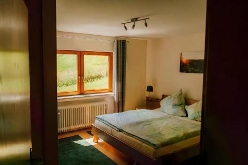 a bedroom with a bed and a window at Ferienwohnung Bästenbach in Bad Peterstal-Griesbach