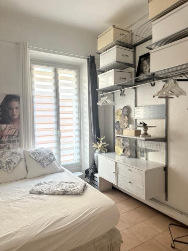 une chambre avec un lit blanc et une commode dans l'établissement Appartement cosy, à Saint-Raphaël