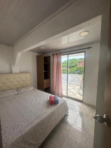 a bedroom with a bed and a sliding glass door at Casona La Española in Cartagena de Indias