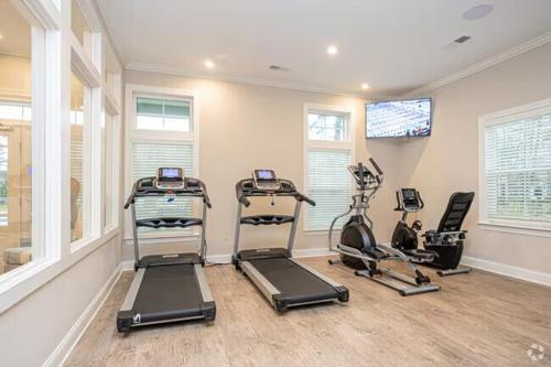 a gym with three exercise bikes and a flat screen tv at The Coastal Comfort Suite in Gulf Shores