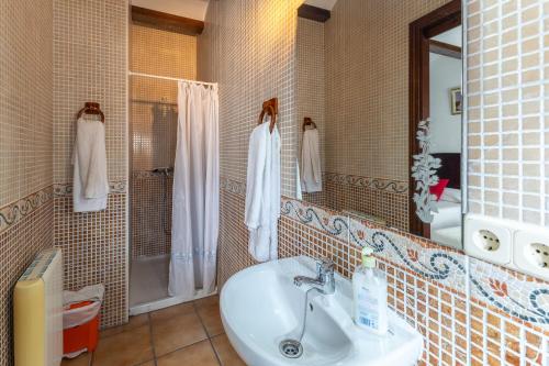 a bathroom with a sink and a shower and a mirror at Casa Rural La Abubilla in Valdelaguna