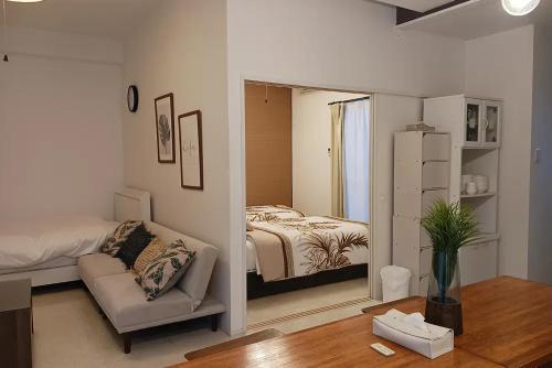 a room with a bedroom with a bed and a mirror at パイナガマリゾート AZAMi-8 in Miyako Island