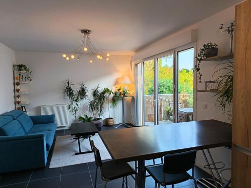 un salon avec une table et un canapé bleu dans l'établissement Studio Bayonne proche gare et centre-ville, à Bayonne