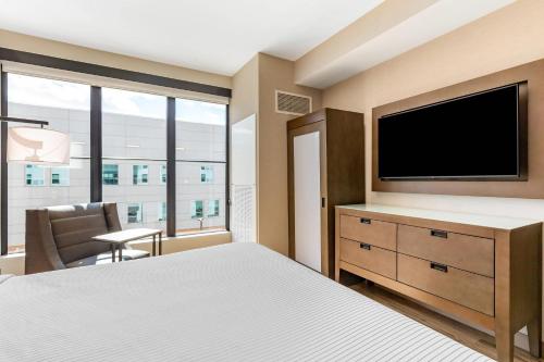 a hotel room with a bed and a flat screen tv at Cambria Hotel New Haven University Area in New Haven
