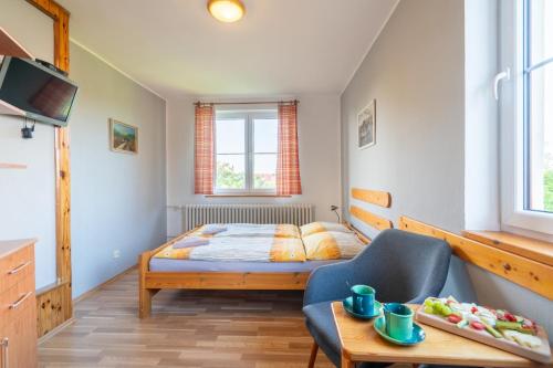 a small bedroom with a bed and a chair at Penzion Na Vyhlídce in Lukov
