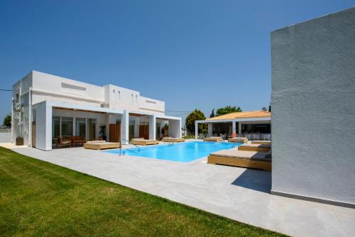 a villa with a swimming pool and a house at Blue Summer Luxury Suites in Kourouta