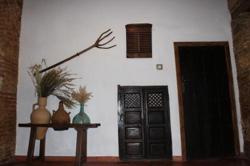 a room with a door and a table with vases at Casa Rural Hidalgo in Ciudad Real