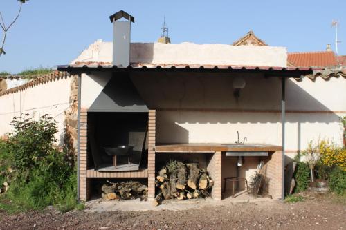 a building with a barbecue with a grill at Casa Rural Hidalgo in Ciudad Real