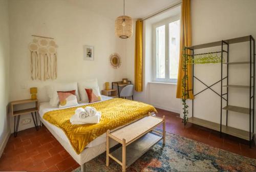 une chambre avec un lit avec deux serviettes dessus dans l'établissement Cocon des halles - Climatisation - Terrasse, à Narbonne