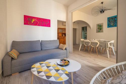 un salon avec un canapé et une table dans l'établissement Cocon des halles - Climatisation - Terrasse, à Narbonne