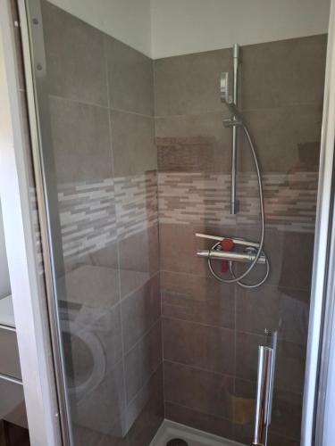 une douche avec une porte vitrée dans une salle de bain dans l'établissement Gîte ty Marie à Benodet, à Bénodet