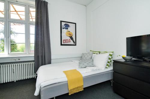 a bedroom with a bed and a flat screen tv at Villa Gertrud - Bed & Breakfast in Kolding