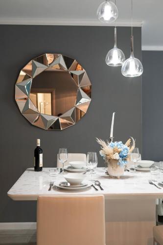 a dining room with a table with a mirror at Ozone Apartment Spa & Pool Beach Resort in Mamaia
