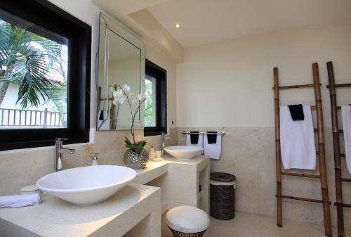 a bathroom with two sinks and a large mirror at Villa Arjuna in Tanah Lot