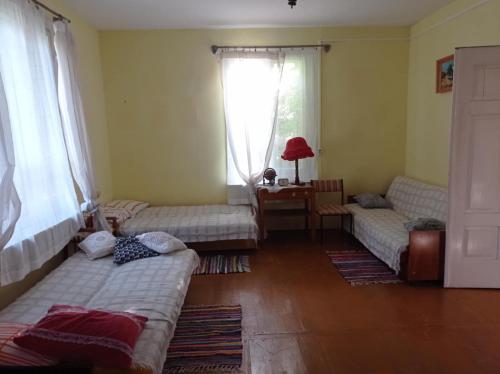 un soggiorno con 2 letti e una finestra di Siedlisko pod starą lipą a Krzczonów-Wójtostwo