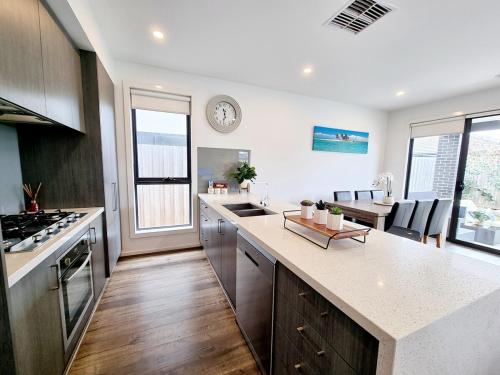 a kitchen with a counter and a dining room at St Germain Estate 4 bedrooms Clyde North home in Clyde North