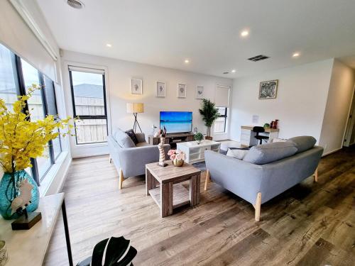 a living room with two couches and a tv at St Germain Estate 4 bedrooms Clyde North home in Clyde North