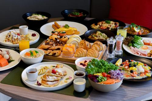 バンコクにあるHilton Garden Inn Bangkok Silomの食べ物の皿やボウルが置かれたテーブル