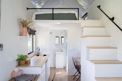 a tiny house with a staircase and a desk at Hill Creek Tiny House 1 by Tiny Away in Perwillowen