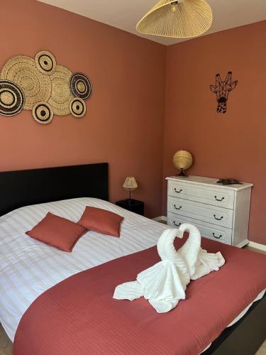 une chambre avec un lit avec un cygne dessus dans l'établissement L échappée bleue, à La Rivière-Saint-Sauveur