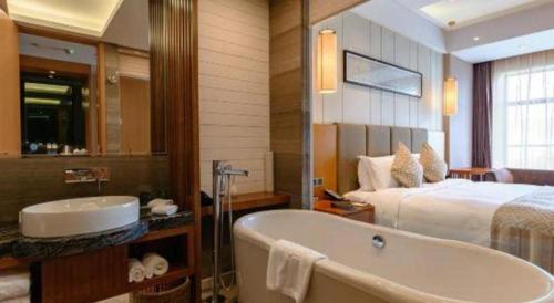 a bathroom with a bath tub and a bed at Suzhou Qingshan Conference Center in Suzhou