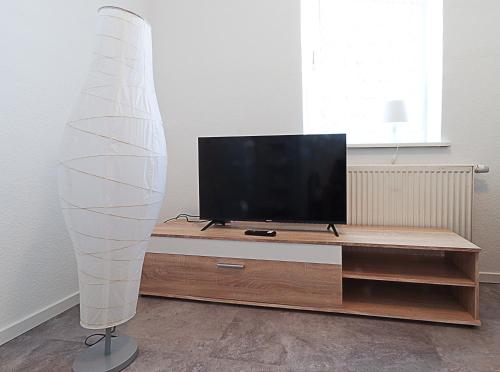 TV de pantalla plana en la parte superior de un centro de entretenimiento de madera en Hertha2, en Celle