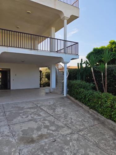 a house with a staircase and a balcony at Villa Leuka San Lorenzo in San Lorenzo