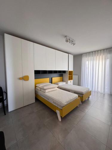 1 dormitorio con 2 camas y armarios blancos en Residence La Vela, en Margherita di Savoia