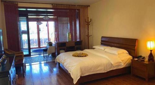 a bedroom with a large bed and a large window at Kunming Dianchi Garden Hotel & Spa in Kunming