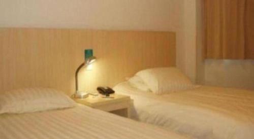 a bedroom with two beds and a lamp on a night stand at JinJiang Inn Nanjing The Confucius Temple Zhonghuamen Metro Station in Nanjing