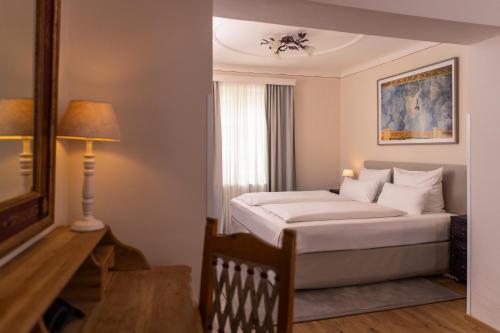 a bedroom with a bed and a lamp and a window at Boutiquehotel Amadeus in Salzburg