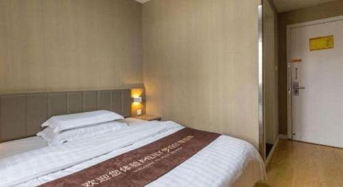 a bedroom with a large white bed in a room at 7 Days Inn Qingdao Si Liu South Road in Qingdao