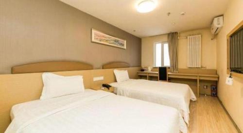 a hotel room with two beds and a window at 7 Days Inn Changchun Zhengyang Street Changchun Park Branch in Changchun